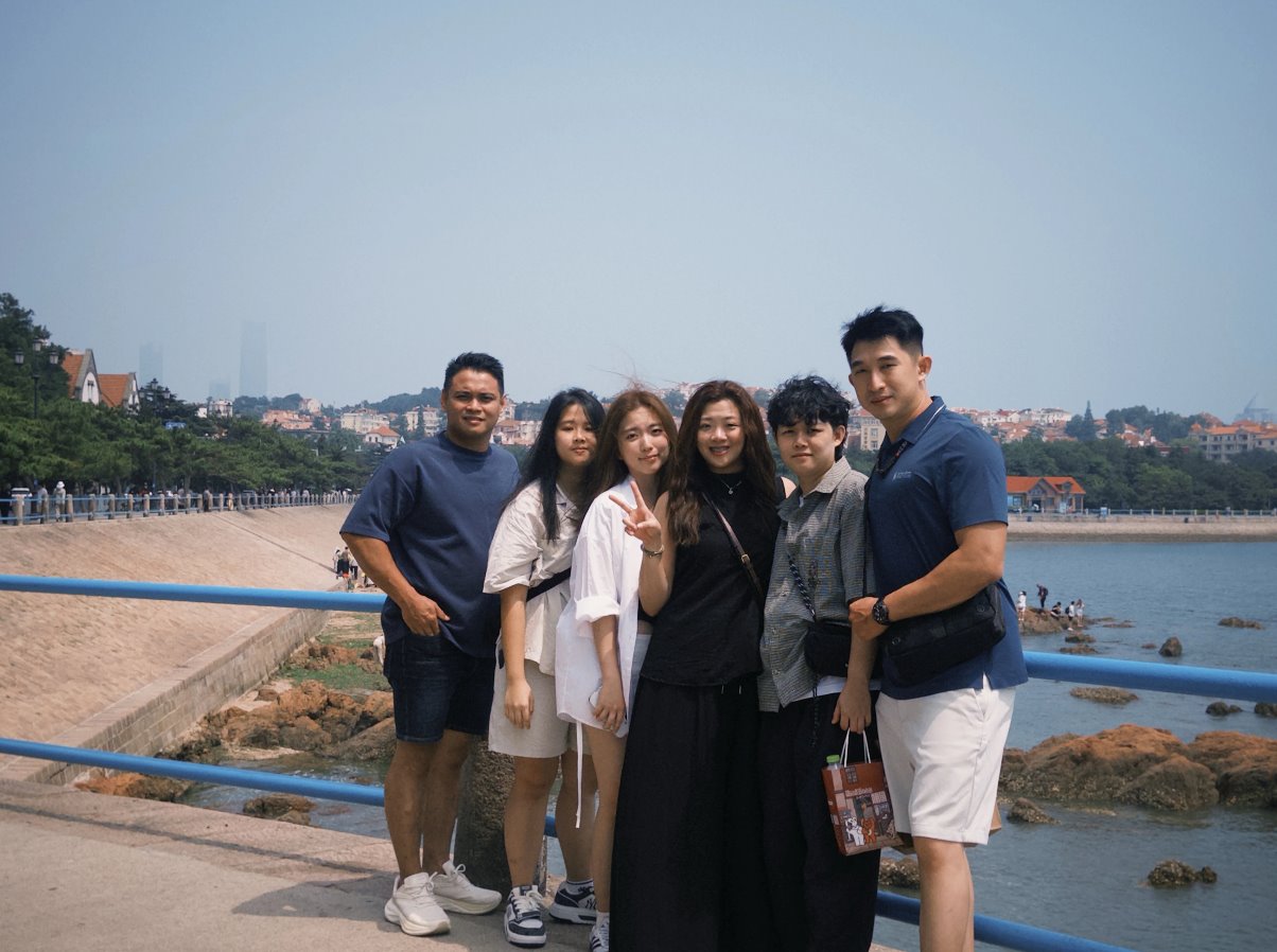 A group of visitors on a coastal promenade in Qingdao